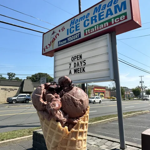 Double scoop chocolate waffle cone in front of the Ryan's Homemade Ice Cream sign