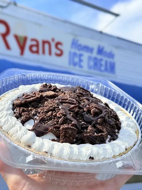 Cookies and cream ice cream pie with whipped cream border and fudge drizzle