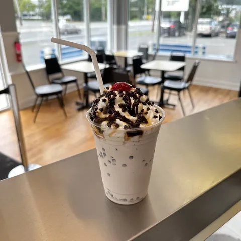 Hand-spun milkshake topped with whipped cream chocolate drizzle and a cherry