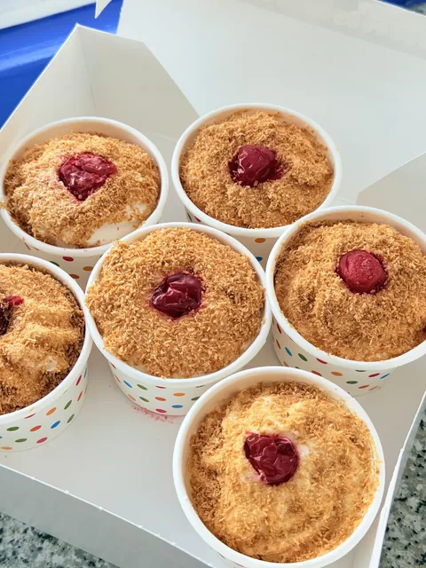 Homemade Italian tortoni cups topped with toasted coconut and cherries