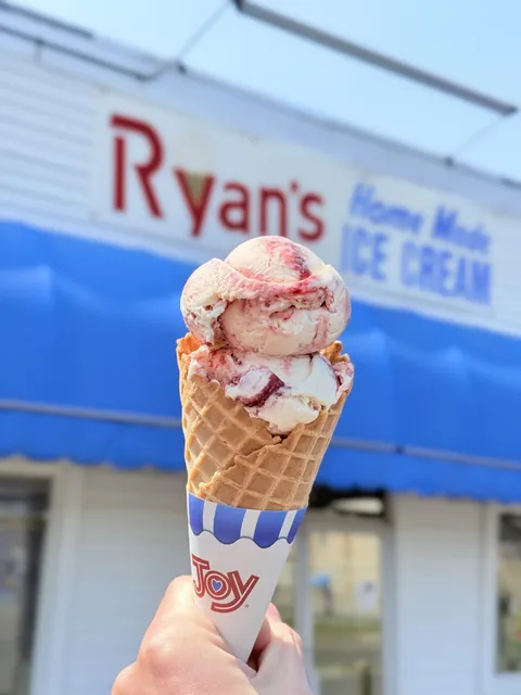 Peanut butter and jelly ice cream scoops on a waffle cone