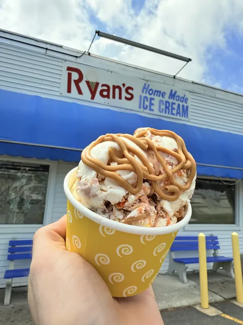 Ice cream topped with a thick peanut butter swirl in a yellow cup
