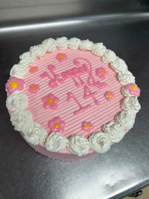 Custom pink frosted ice cream cake with piped flowers