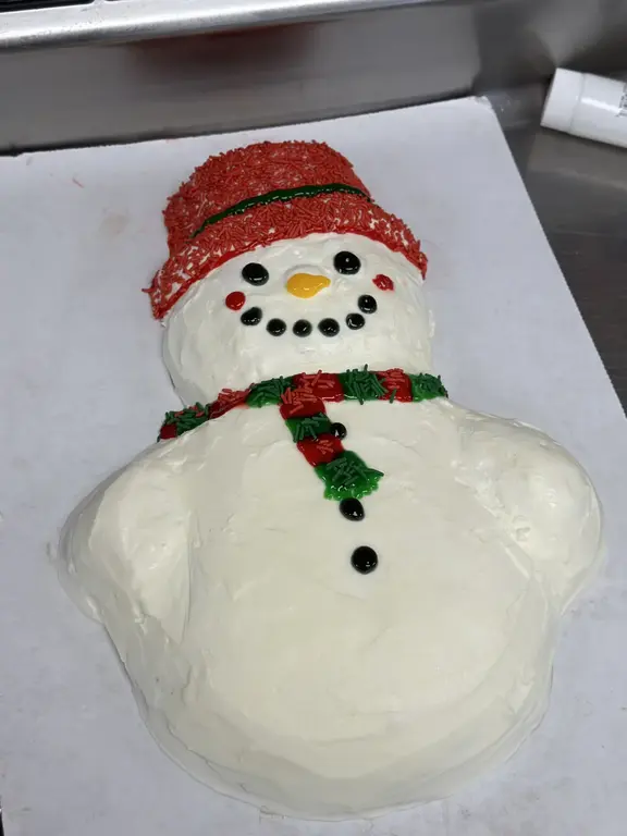Snowman shaped holiday ice cream cake with red hat and scarf